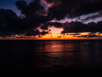 Scenic view of sea against dramatic sky during sunset