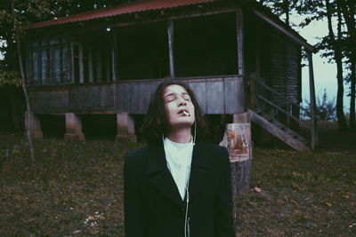 Teenage girl smoking cigarette while standing on field