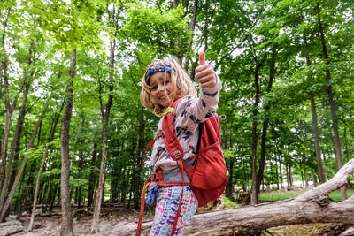Low angle view of woman standing in forest