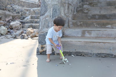 Boy playing with shovel at beach