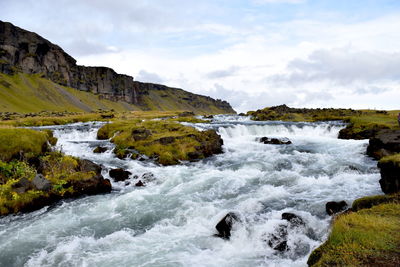 Scenic view of gushing river against sky