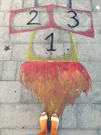 Low section of woman standing on road