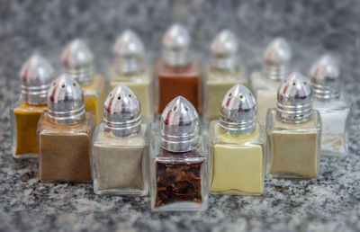 Close-up of spices arranged in glass containers on marble