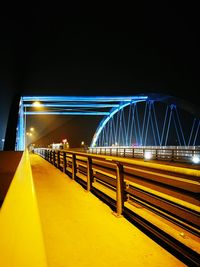 Light trails on bridge against clear sky at night