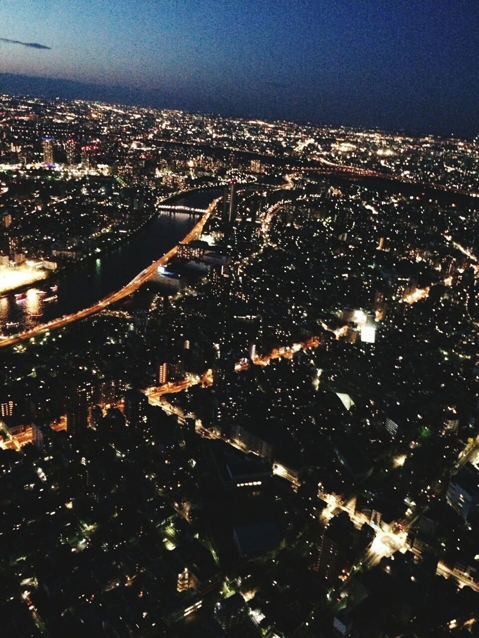 aerial view, cityscape, city, night, illuminated, high angle view, building exterior, architecture, crowded, landscape, built structure, sky, clear sky, no people, outdoors, flying, residential district, blue, nature, airplane