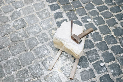 High angle view of cigarette on cobblestone street