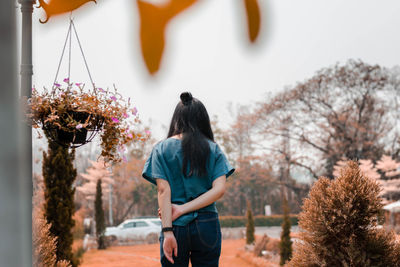 Rear view of woman standing on footpath