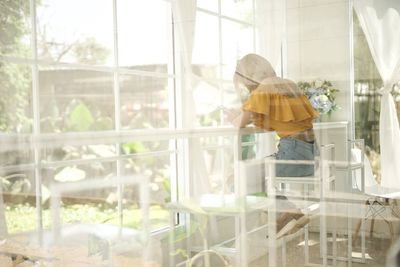 Rear view of a woman in glass window