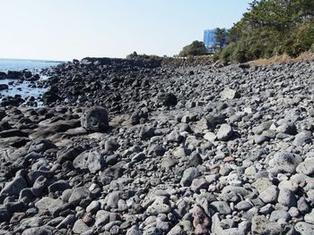View of rocks on beach against clear sky
