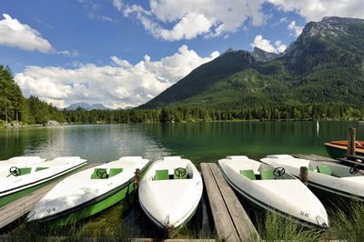 Boats moored in lake against sky