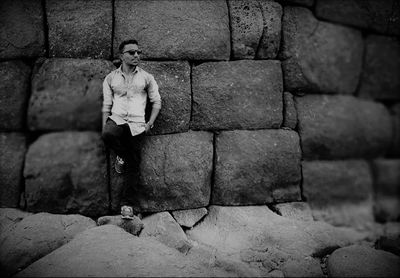 Full length of young man standing against wall