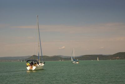 Boats sailing on sea against sky