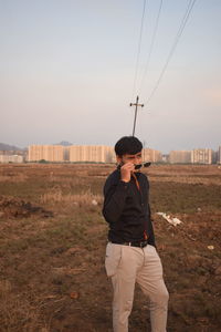 Full length of man standing on field against sky