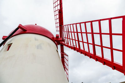  low angle view of red windmill against sky