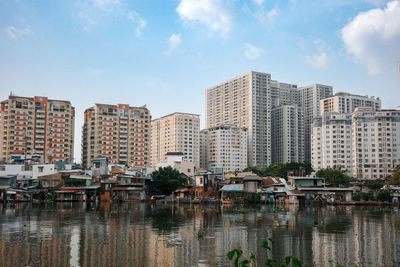 Riverside slums with apartment building behind in ho chi minh city, viet nam