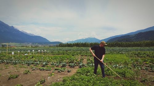 Man working on field against mountains