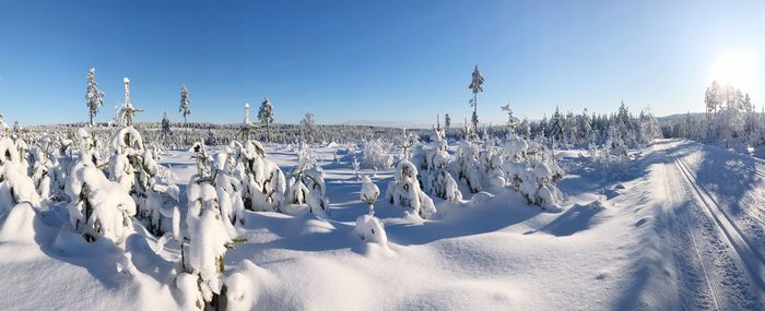 Panoramic shot of snow covered field against sky