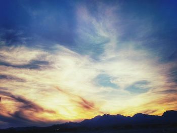 Scenic view of mountains against cloudy sky