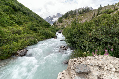 Scenic view of river amidst rocks against sky