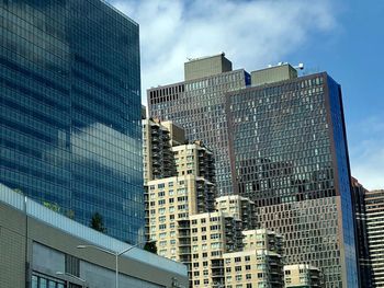 Low angle view of modern buildings in city against sky