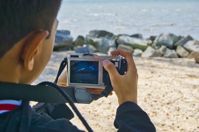 Midsection of woman using mobile phone at beach