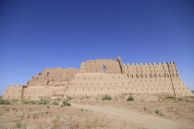 Low angle view of rock formations against clear blue sky