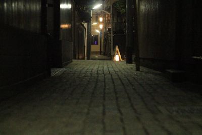 Illuminated street amidst buildings at night