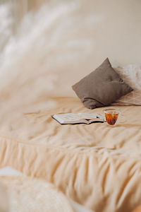 Cozy home. beige bed with pillows, books and cup of tea