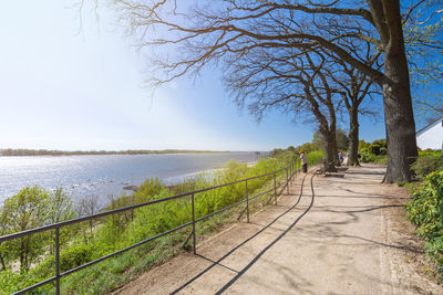 Footpath by sea against clear sky