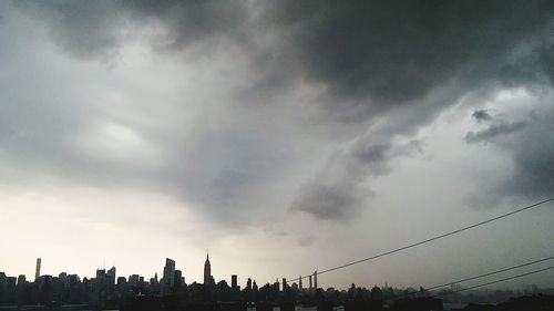 View of cityscape against cloudy sky