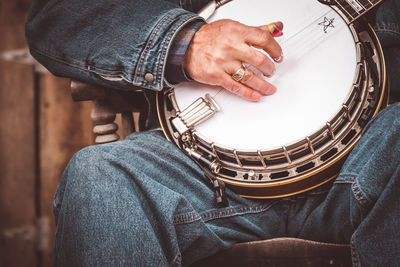 Midsection of man playing banjo