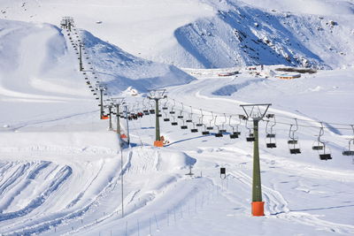 Ski lift over snow covered mountain