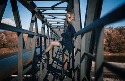 Woman seen through railing on bridge