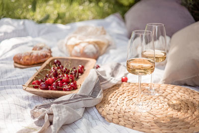 Aesthetic picnic outdoors with wine glasses bread berries and flowers. rustic picnic 