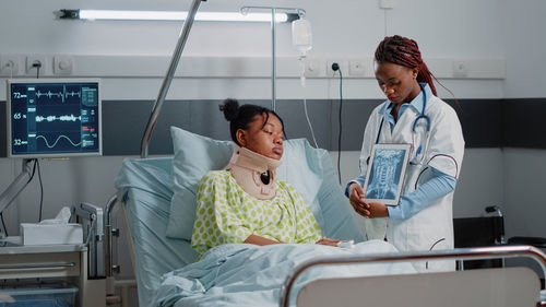 Doctor showing x ray to patient at hospital