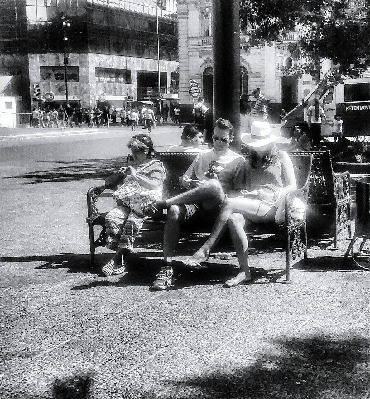 building exterior, built structure, architecture, animal themes, sunlight, land vehicle, street, outdoors, chair, sitting, city, grass, mode of transport, day, transportation, tree, incidental people, shadow, full length, park - man made space