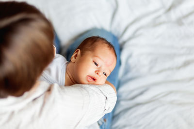 Woman holds her child. mother comforts her son or daughter. baby with big birthmark on forehead.