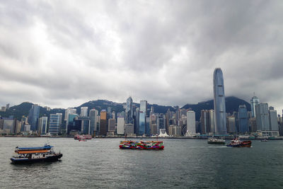 Buildings in city against cloudy sky