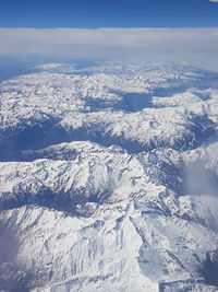 Aerial view of snowcapped mountains against sky