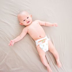 Portrait of cute baby boy lying on bed