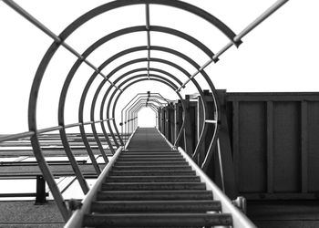 Directly below shot of ladder on building against clear sky