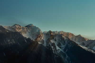 Panoramic view of snowcapped mountains against clear blue sky