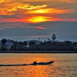 Boats in sea at sunset