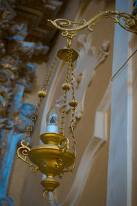 Low angle view of electric lamp hanging on ceiling in building