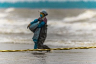 Man holding rope on beach