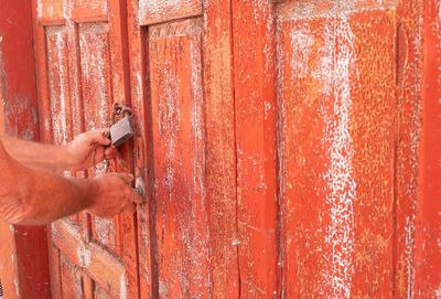 Cropped hands holding door padlock