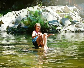 Smiling girl sitting in lake at big basin redwoods state park