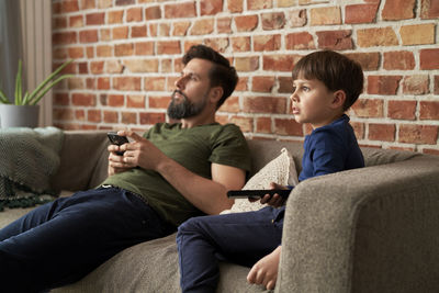 Boy using mobile phone while sitting on sofa at home