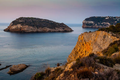 Rock formations in sea against sky