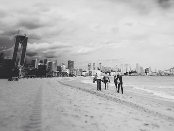 People in city against cloudy sky